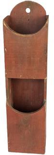 K1777 Early 19th century Pennsylvania original red painted double wall box / pipe box featuring curved pocket openings with tapered edges and an arched back with hole for hanging purposes. Small square head nail construction. The wood is pine. Measurements: 5 5/8 wide x 4 3/8 deep x 21 7/8 tall.