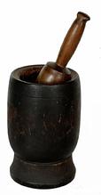 H952C 19th century turned wooden Mortar and Pestle in original black painted surface. Nicely turned shape with simple incised ring around the outside and a molded interior lip surrounding the opening of the Mortar. Natural patina interior. Several visible surface cracks from age and shrinkage, however none go all the way through. The pestle retains natural patina finish. Measurements: 4 3/4" diameter x 7 3/4" tall. Pestle is 9 long.