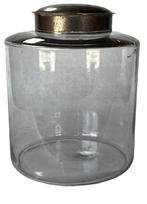 K232 Large, late 19th century Apothecary jar with tin lid. The jar is a hand-blown clear glass with remnants of the pontil on base. The glass is wavy with minor air bubbles and fine scratches in some places. Measurements: 8 diameter x 10 tall with lid.
