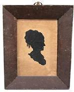 K46 18th century Pennsylvania framed hollow-cut silhouette of a woman against a black fabric background. Original frame and thick, bubbled glass that is secured via small �T� and square-head nails. The very early ring intact on top for hanging purposes also appears to be original.  In this type of silhouette, the profile was cut out and discarded. The remaining surrounding paper was then placed against black paper or silk fabric to prominently reveal the wonderful profile. Circa 1790 � 1810. Framed measurements: 7 &frac12;� wide x 7/8� thick x 9 &frac14;� tall.