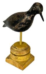 H341 Late 1800 Hollow Black Belly Plover two-piece construction, tack eyes, original black paint, mounted on a base for display purposes. Original surface retains evidence of being shot over. Measures approximately 10 long. Mounted height is 10 ¼ tall. 