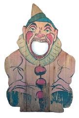 G388 Early 20th century wooden tossing game. The face of a Clown lithographed on the wood panel with hole in his mouth. Try to throw a ball in his mouth to determine your score. Measurements: 15 3/4" wide x 24 1/4" tall x 3/4" thick.