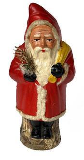 L481 Early 20th century Belsnickel holding a feather tree with a yellow pack hung over his shoulder. Papier Mache construction. Approximate measurements: 2 ¾-3 diameter x 9 ½ tall.