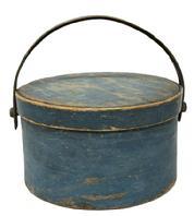 M1129 19th century original blue painted wooden bail handle pantry box with remnants of makers stamp (REUBEN HYDE / WINCHENDON) on top, center of lid. Sturdy, thick wooden swing handle is attached with large buttonhead wooden pins, and the thick walled, overlapping steamed and bent wood sides are secured with tacks. Clean, natural patina interior. Measurements: 11 ½ diameter (bottom) x 12" diameter (top) x 6 ¾ tall (not including handle)