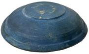 M1149 Early 19th century lathe turned wooden bowl with original old dark blue paint inside and outside featuring a lipped rim and slow turned lathe marks throughout resting on a footed base with hand hewn center. Out of round. No cracks. Measurements: 6 5/8" x 7" top diameter x ~1 ½ x ~1 5/8" deep, depending on where measured. Footed base is 3" x 3 ¼ diameter.