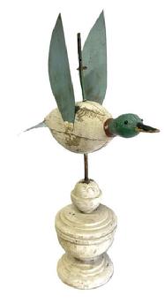M280 Original painted Folk Art Duck Weathervane. Wooden body with tack eyes and tin tail and wings. Mounted in an original white painted architectural wooden base for display purposes. Measurements: ~14 ¾ long x 4 ¼ wide (tail). Overall mounted height is ~20 tall.