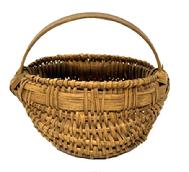 M1107 Fantastic Pennsylvania tightly hand-woven miniature oak splint egg / buttocks basket boasting woven details at the junctures of the two main ribs as well as along the bottom center of the basket. Main juncture of the basket is secured with a tiny tack on each side showing oxidation from age. This wonderful little basket retains original aged, natural patina surface. Great size and condition! Measurements: 3 ½ x 4 ¼ diameter x 2 ¼ tall (sides) x 3 ½ tall (including handle).