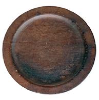 L510 Wooden plate with wide lipped edge resting on a slightly raised foot. Dark, natural patina with tight age cracks and surface wear. Out of round. Measurements: 7 1/8 x 7 ½ diameter x ~ ¾tall. The lipped edge is ¾ wide and ~1/8 thick.