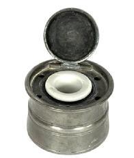 L268B 18th century Pewter ink well fitted with five quill holes and hinged lid covering its original removeable porcelain insert ink pot. Flared rim with tapered sides boasting decorative incised rings above and below a raised embossed center ring. Circa 1780s – 1800. Measurements: 3 ¼” diameter x 2 1/8” tall.