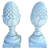M156 Very early 20th century pair of matching solid cast iron Pineapple finials with geometric diamond shaped details on top and a series of detailed curved leaves and shaped rings below resting on square bases. Surface retains several layers of old white paint. Extremely heavy. Circa 1900-1920s. Approximate measurements: Bases are 8 square x ~20 ¾ tall.