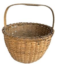M158 Sturdy 19th century round woven oak splint basket with natural surface, thick, hand-carved steamed and bent, notched handle that is woven into the sides. Double wrapped, double rim. The tightly woven bottom includes a slightly bumped up interior for help with weight distribution and airflow. Measurements: 14 ¾ x 15 top diameter x 15 ½ tall with handle. The sides are ~8 ½ tall.