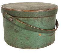 **SOLD** L112 19th century Bail Handle Pantry Box in original green painted surface. This Pantry Box is sturdy, thick walled with its original wooden bail handle bearing an early break repair to one side of handle. Overlapping bentwood sides secured with small metal tacks. The lid has overlapping finger joint secured with small tacks. Nice wear with natural patina interior. Measurements: 11 ¾ top diameter x 11 ¼ bottom diameter x 7 tall (not including handle).