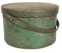 L112 19th century Bail Handle Pantry Box in original green painted surface. This Pantry Box is sturdy, thick walled with its original wooden bail handle bearing an early break repair to one side of handle. Overlapping bentwood sides secured with small metal tacks. The lid has overlapping finger joint secured with small tacks. Nice wear with natural patina interior. Measurements:  11 ¾ top diameter x 11 ¼ bottom diameter x 7 tall (not including handle).