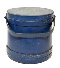 M1134 Pennsylvania lidded wooden Firkin in the original dry blue painted surface, featuring tongue and groove softwood staved sides, overlapping joint wooden bands secured with small tacks and steamed and bent wood handle with wood peg attachments. Clean, natural patina interior. Found in Pennsylvania. Measurements: 11 ¼ top diameter x 12 1/8 bottom diameter x 11 ¼ tall.