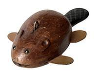 J343 Folk Art hand-carved wooden fishing decoy depicting a small Beaver. Solid wooden body with tin front/back legs. Detailed shaping to the body, tail, head, and ears. Very realistic carved details on the tail, original painted surface and glass inset eyes. Metal weight embedded in the underbelly. From a Wappinger Falls, NY collection. Approximate measurements: 4 7/8 long x 2 ½ wide x 1 ¼ tall