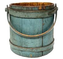 **SOLD** M166 Very early 19th century New England Wooden Firkin bearing its exceptionally beautiful original dry blue painted surface. A small note taped inside reads: Firkin Purchased at Sturbridge Antiques Charlton Rd. Sturbridge, Mass. April 20,1969. The staved sides are tongue and groove construction secured with wooden bands with overlapping fingers secured with small tacks and one band has a rosehead nail at the very tip. The steamed and bent wooden handle is secured with wooden pegs and pins and there is an early repair to a split at the very end of the handle below the peg. Measurements: 9 ¾ top diameter x 11" bottom diameter x 10 ½ tall (not including handle)