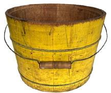 **SOLD** K1856 Late 19th century original vibrant chrome yellow painted bucket from Pennsylvania with arched wire bail handle and turned wooden grip. The interior is old natural patina. Tongue and grooved staved construction held in place with thick wire bands. A childs penciled drawings adorn one side Measurements: 13 ¼ top diameter x 11 ¼ bottom diameter x 9 ½ tall.