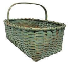 M236 Rectangular gathering basket in original robin egg blue paint. Extremely sturdy woven basket boasts double steamed and bent rims that are double wrapped and a thick, steamed and bent handle that is notched and woven into the sides of the basket. The bottom of the basket features 1 ¼- 1 ½ wide woven slats. Measurements: 23" long x 16" wide x 8 ½ tall sides (approx. 13 ½ tall at handle).