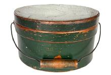 **SOLD** L116 19th century New England bail handle Pantry Box in the original green paint with wire bail-handle with turned wood grip. The overlapping steamed and bentwood sides are secured by small tacks. Natural patina interior. Measurements: 9 ¼ diameter x 5 ¼ tall. 