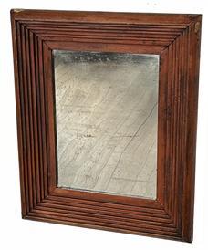 K263 Mid-19th century Pennsylvania looking glass featuring an exceptional stepped molding frame with boldly rounded edges retaining its original red painted surface. Appears to be the original silvered mirror. Combination of square head and T nail construction. The wood is pine. Overall measurements:  13 ¾ wide x 2 deep x 16 ¾ tall.  Mirror area measures 8 wide x 11 tall.