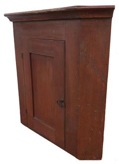 D580 19th century Pennslyvania hanging Cupboard, original red paint, . The interior is all natural, with applied cove molding at the top beautiful back boards helding place with squard head nails Measurements are: 27 1/2" tall x 21" corner