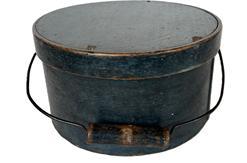 K1737 19th century New England Bail Handle Pantry Box with the original dry indigo blue painted surface. The overlapping bentwood sides are secured with small metal tacks. The sides of the Box are fitted with a pair of oval stamped tin handle mounts. Fitted with an arched wire swing handle with wooden hand grip bearing remnants of the original indigo blue paint. Natural patina interior. Measurements: 9 ¾ top diameter x 5 ¼ tall.