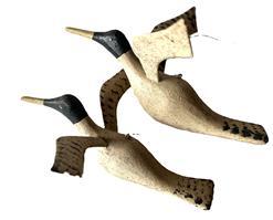 L36 Pair of miniature hand carved flying duck decoys bearing original painted surfaces and delicately thin carved wings. Solid wood. Carver unknown.  One measures: 5 &frac12;� wingspan x 6 &frac14;� long x ~2� tall and the other one measures 6� wingspan x 7� long x ~3� tall.  