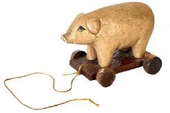 L134 Folk Art carved wooden Pig Pull Toy. Solid wooden carved pig features painted and textured surface replicating skin with detailed carved ears, mouth, snout and very expressive eyes. It is mounted on a wooden base with carved textured details. The wooden wheels move freely. Missing its tail and has one mix-matched wheel � otherwise in great condition. Approximate Measurements: 8 &frac12;� long x 4 5/8� wide x 5 &frac34;� tall.  