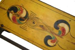 W59 ANTIQUE PAINT DECORATED CHILD’S SLED. red and blue, yellow paint decorated top, Wrought iron runners. some wear to the paint
