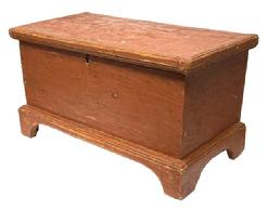 M317 Small 19th century Pennsylvania blanket chest bearing original red painted surface with dovetailed case and applied, dovetailed bracket base with molded edge and cut out feet. Applied molded and mortised edge surrounds the lid. Lidded glove till inside. There are several names, and the date 1887, handwritten inside the chest. Pine, six board construction. Natural patina interior. Measurements: 25 ½ wide x 13 deep x 14 tall.