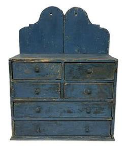 **SOLD** M240 19th century New England six (6) drawer Apothecary with old blue over the original blue painted surface featuring a tall shaped cut out back and unusual drawer configuration. The drawers are dovetailed with beaded edges surrounding the fronts. The drawer stretchers are mortised into the case. Square head nail construction. Circa 1820. Measurements: 19 ¾ wide x 9 deep (bottom) x 8 5/8 deep (case) x 26 1/8 tall (back) x 16 ¼ tall (front).