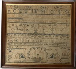**SOLD** K1796 19th century American Schoolgirl Needlework Sampler Signed “Mary A. Snider her Sampler worked in the year of our Lord 1834” “Age 1 (?) Years”. Sampler is stitched with what appears to be cotton threads over linen material and boasts blues, browns, tans, green, pink and ecru colors in a row-by-row format featuring repeating alphabets, numbers, and geometrical patterns. Various versions of flowers, birds and trees in baskets / urns and a multi-storied house adorn the field of the sampler. This Sampler has been professionally mounted and framed and bears the original framer’s label from “Buckingham’s Inc. – Washington D.C.” intact on back. Framed measurements: 21” wide x ¾” thick x 19 ½” tall.