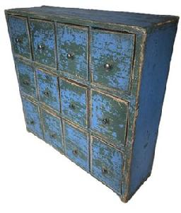 K1731 Twelve drawer 19th century Apothecary bearing vivid old blue over original green painted surface featuring three rows of drawers with mortised stretchers. The bottom row of drawers if slightly larger than the top two rows. Each of the drawers has shaped sides and original pale-yellow painted interiors. Found in Pennsylvania. Pine with small wire nail construction. Great size versatile enough that it can sit atop a flat surface or be hung on the wall. Measurements: 18 ½ wide x 5 ½ deep x 18 tall.