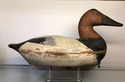 E299 Canvasback decoy carved by John (“Jack”) McKenney (1889-1973) from Chestertown, MD. Brand on the bottom reads: “E. A. VOSHELL” who was Mr. McKenney’s father-in-law. Bill Shauber, another carver from Chetertown, MD, states Mr. McKenney was his Uncle and that he only carved approximately 500 birds in his lifetime, mostly during the 1950s. This decoy retains both its wooden keel (with lead lining the bottom outer portion of the keel) and its original coat of paint with the wear around the middle section of the bird being attributed to significant use in icy conditions.
