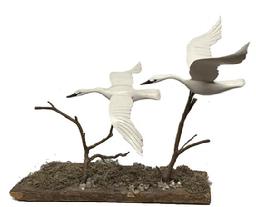 M288 Unique Folk Art carving featuring two individual, nicely detailed and hand painted, Swans in full flight. Unsigned. Mounted on branches attached to a barnacle covered piece of driftwood. The base is 18 ¼ long x 5 wide. Approximate overall height is 16 tall. The swans measure approximately 13 ½ wide x 8 ¾ long and 10 ½ wide x 8 ½ long.