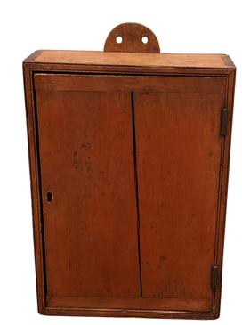 F86 19th century New England single door hanging Cupboard in original red with a tombstone back for hanging. The door is one board with bread board ends, double bead on front Case, with a dovetailed case. Document inside is dated 1837. Measurements are: 16" wide x 24 3/4" tall x 5 1/2" deep