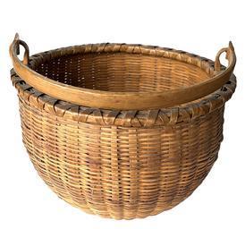 **SOLD** L81 Great large-sized 19th century round woven splint oak swing handle basket with original surface, bearing a thick, sturdy hand-carved steamed and bent swing handle that is notched and woven into the sides. The double wooden rim is double wrapped for added strength. The tightly woven bottom includes a slightly bumped up interior.