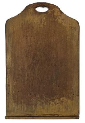 **SOLD** K1665 19th century New England original mustard painted cutting / peel board with attached runner to act as a riser / stop, depending on which side of the board is being used at the time. Nicely shaped end with cut out hole for carrying / hanging. The wood is pine. Great patina and wear with visible chop marks from years of use. Measurements: 29 ½ long x 19 wide x ¾ thick (1 ¼ thick where extra strip is attached)
