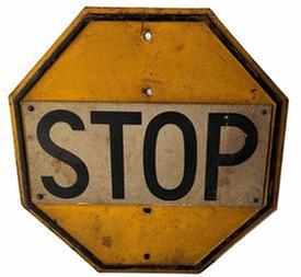 H5 original c. 1920's yellow & black enameled single-sided stop sign with embossed border. the octagonal-shaped traffic sign shows surface wear consistent with age. stop signs originated in michigan in 1915.