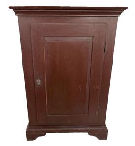 L537 Early 19th century one door cupboard with original painted surface, dovetailed case and beautiful, fully mortised raised panel door that retains its working lock with key. Applied molding surrounds the top and cupboard rests on applied bracket base with cut out feet. Clean, natural patina interior with sturdy shelves for storage. The wood is pine with square head nail construction. Of note - the back board is constructed of one wide board that has split almost exactly down the center because of age and the secure way it was nailed to the back. Measurements: 29 wide x 18 deep x 42 ½ tall. Provenance: From a private collection.
