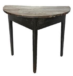 L211 18th century Maryland demilune table in old black paint. Table is circa 1780-1790s and features a semi-circular two-board top secured to the apron with large rosehead nails and T nails over a plain, triangular-shaped apron with beaded edge along the bottom that rests on three gracefully tapered legs. Measurements: 31 ¼ wide x 17 ¾ deep x 28 ½ tall.