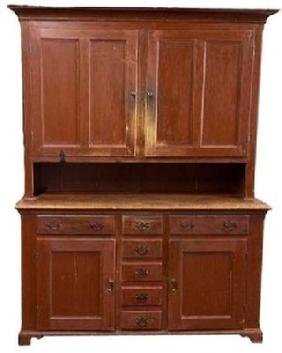 L166 Unique late-18th century to early 19th century Lancaster County, Pennsylvania original red painted two-piece stepback cupboard boasting an unusual configuration resting on an applied dovetailed bracket base with decorative cut out feet. The layout of the top consists of two fully mortised and pegged split panel doors that open to reveal shelves with plate grooves and a spoon rack along the shelf fronts. The layout of the lower part of the cupboard consists of two dovetailed drawers over two panel doors with five smaller dovetailed drawers in the center. Cupboard is dovetailed and mortised and pegged construction with T nails and square head nails. Circa 1780 1810. Measurements: 58 ½ wide (at waist) x 21 deep x 82 ½ tall.