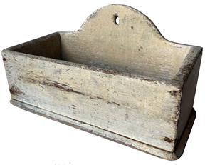 F208 Early New England original painted American hanging wall candle box, with “tombstone shaped back” ca 1820 to 1850 Old dry oyster white paint over the original red paint square head nailed construction Measures 6 3/4”high X 11 1/2” wide X 5 3/4” deep.