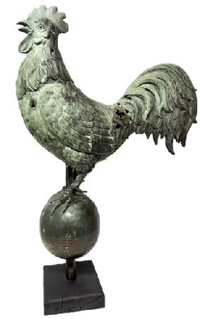 **SOLD** M221 Spectacular 19th century hollow-bodied Copper Rooster Weathervane featuring a bold Rooster perched in a crowing stance atop a large hollow bodied Ball. Exceptional details throughout especially to the beak, face, feet and feathers. Hand crafted from molded copper, featuring a verdigris patina caused by long term exposure to the elements and evidence of being shot at in several areas. Mounted on a later wooden base for display purposes. Approximate measurements: ~22 long x ~6 ½ wide x ~35 overall height. Base measures 7 ¼ x 8.