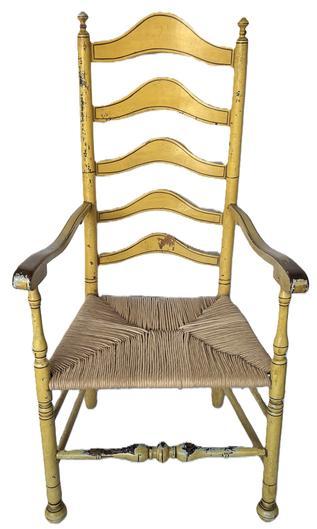 K1818 Fantastic Delaware Valley 18th Century, arched ladder back armchair retaining mustard yellow painted surface with pinstripe decoration and old woven rush-type seat. Chair retains nicely turned finials on top, as well as its original ball feet and boasts bold ball turnings on the front rung with nice wear. The five arched slats along the back are all mortised and pegged. Very sturdy. Retains good height. Circa 1750 - 1790. Measurements: 46 ½ tall (back) x 24 wide (front arms) x 17 ½ deep (seat). Seat height is 17.