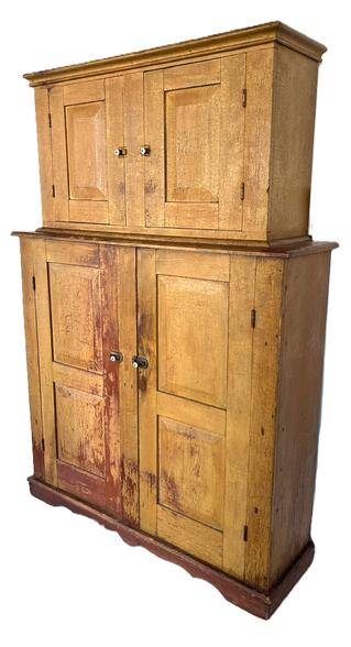 **SOLD** K1577 Mid 19th century New England two-part Linen Press bearing old mustard painted surface over the original red paint. Very unusual form. Slightly raised panels adorn all four of the fully mortised doors. Applied molding surrounds both top and bottom. Applied base boasts a decoratively cut out front. Removeable interior shelving in the bottom section for varied storage options. Square head nail construction. The wood is pine. Measurements: 54 1/8 wide x 15 5/8 deep x 78 ¼ tall. 