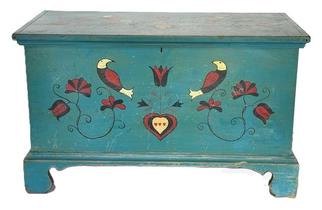 **SOLD** M55 Exceptional early to mid-19th century Pennsylvania Child's Blanket Chest retaining its original blue painted surface adorned with hand painted Pennsylvania Dutch motif decorations including hearts and birds. The wood is pine, six-board dovetailed construction case with applied molding around the lid and an applied bracket base with wonderful cut out feet. Clean, natural patina interior with lidded till. Identified on back (partially illegible)
..Lancaster Pa. Measurements: 28 ¾ wide x 14 ½ deep x 17 ½ tall.