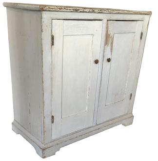 D560 Early 19th century two door storage Cupboard, circa 1810 - 1820 in old white paint. Two panel doors full mortised and pinned one board construction. The wood is all white pine with an applied base and pit-sawed back boards held in place with square head nails. This cupboard was made to fit in corner. Measurements are: 17 1/4" deep x 36" wide x 36" tall