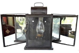 **SOLD** L214 Rare style 19th century large glass and tin Gunning Light / Lantern with three glass panels and a folding mirrored reflective panel on each side. The front glass panel is a hinged door for access to the fuel chamber / glass chimney inside.  Lantern has a heavy wooden base for stability. Sturdy wire bail handle on top for carrying purposes. There are two original long heavy wire �hooks� attached to top to secure the side panels in both the open position, and to lock them securely in the closed position. Very unique design. Measurements: 11 &frac14;� wide (with reflector sides closed) x 8 &frac14;� deep x 18 &frac34;� tall (with handle up). Overall width with reflective panels locked in the open position is 30 &frac12;� wide. 