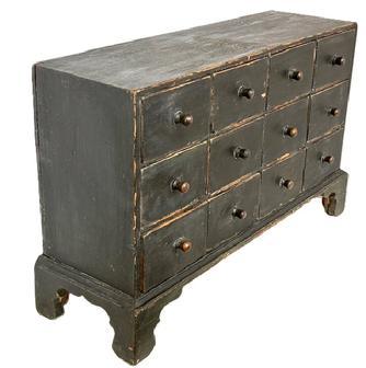 **SOLD** L406 19th century New England 12 drawer Apothecary in original Windsor green paint with dovetailed case and drawers, resting on an applied bracket base with decoratively cut out feet. The wood is pine with small wire nail and dovetail construction. Circa 1840s. Measurements: 34 ½ wide x 10 ½ deep (top) x 11 ½ deep (base) x 22 tall.